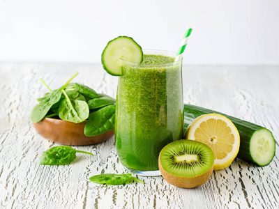 Fresh green detox smoothie on white wooden background, diet and health concept, vitamins